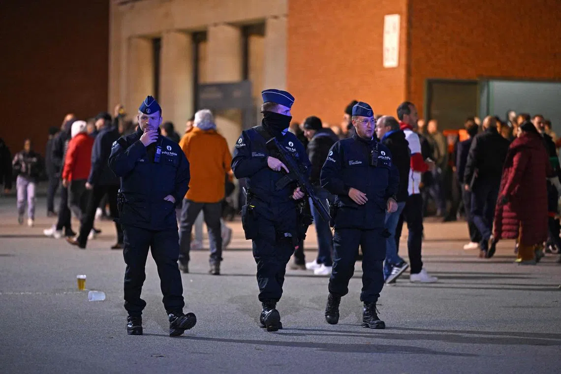 TOPSHOT - Police officers patrol as supporters leave the King Baudouin Stadium following the Euro 2024 qualifying football match between Belgium and Sweden in Brussels on October 16, 2023, after two Swedes were shot dead in an attack in Brussels. Belgium's Euro 2024 qualifier against Sweden was abandoned at half-time and fans were kept in the stadium for security reasons after two Swedes were shot dead in an attack in Brussels onOctober 16, 2023. (Photo by JOHN THYS / AFP)