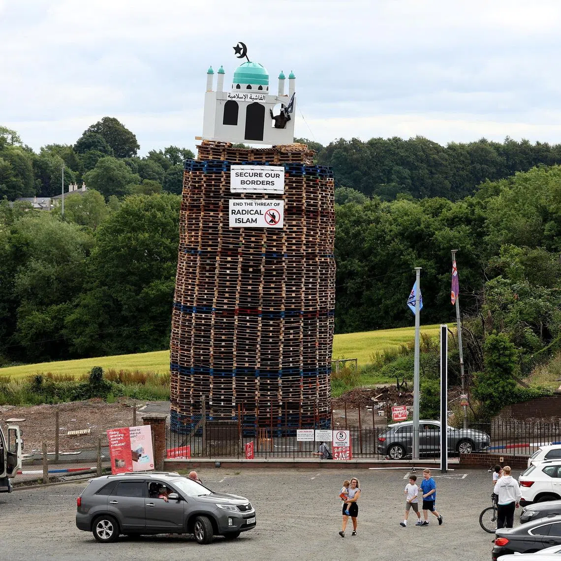 Banners below the structure read “secure our borders” and “end the threat of radical Islam”.