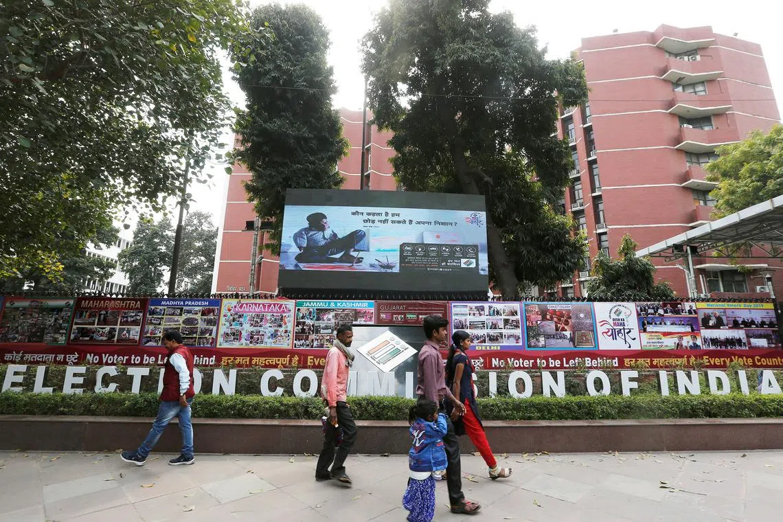FILE PHOTO: People walk past the Election Commission of India office building in New Delhi, India March 11, 2019. REUTERS/Adnan Abidi/File Photo