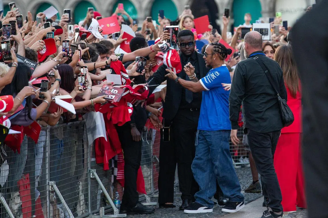 Ferrari's Lewis Hamilton greets fans during an event at the Royal Palace in Milan.