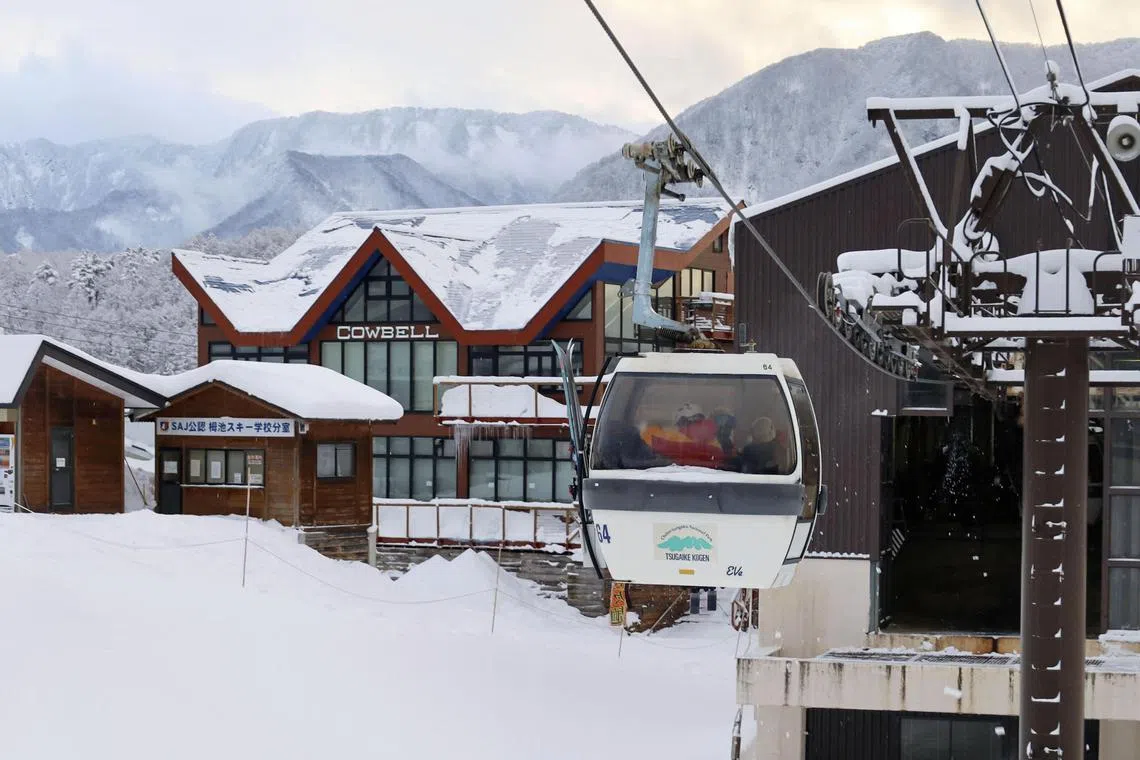 Rescue workers ride a gondola at a ski resort as they take part in a search for missing skiers following an avalanche the previous day in Nagano Prefecture.