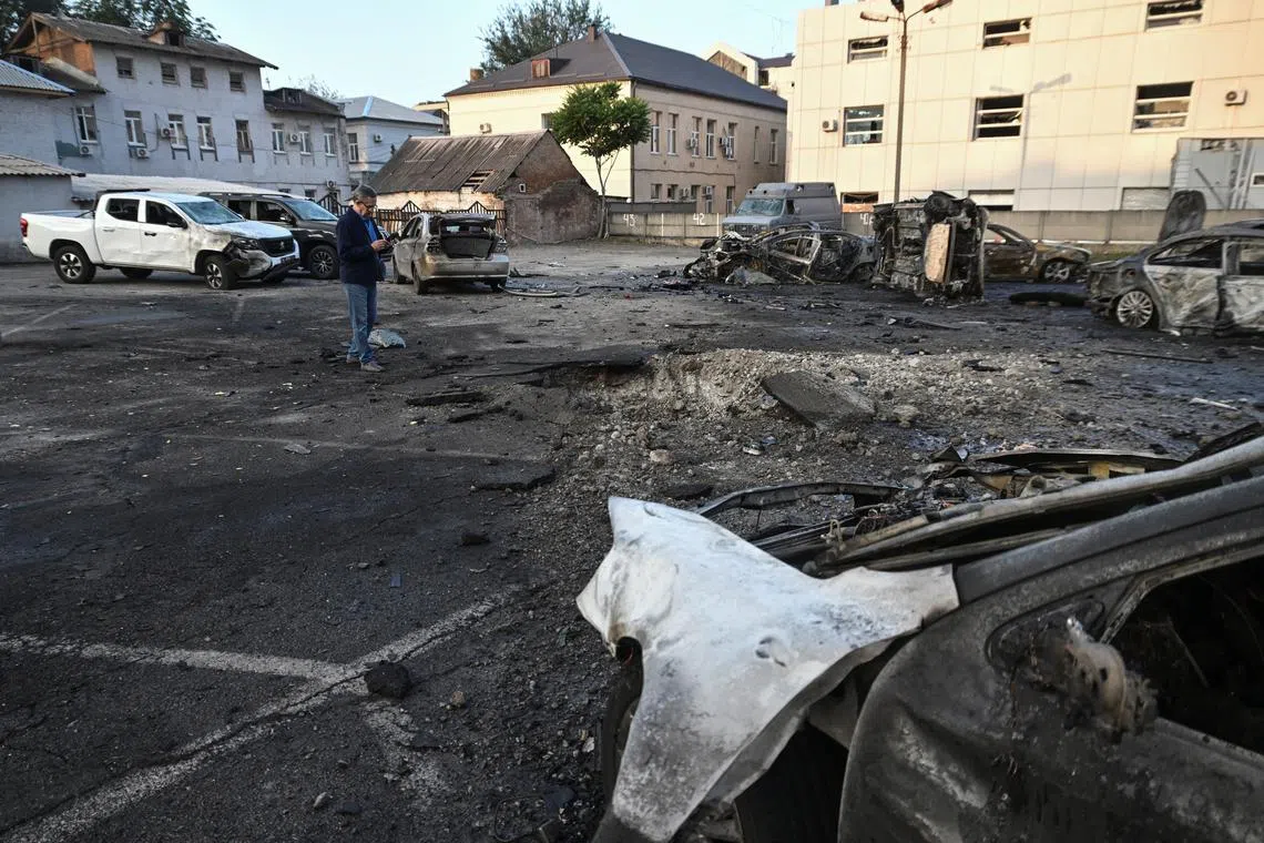 FILE PHOTO: A resident stands next to cars destroyed by a Russian drone strike, amid Russia's attack on Ukraine, in Zaporizhzhia, Ukraine June 14, 2025. REUTERS/Stringer/File Photo