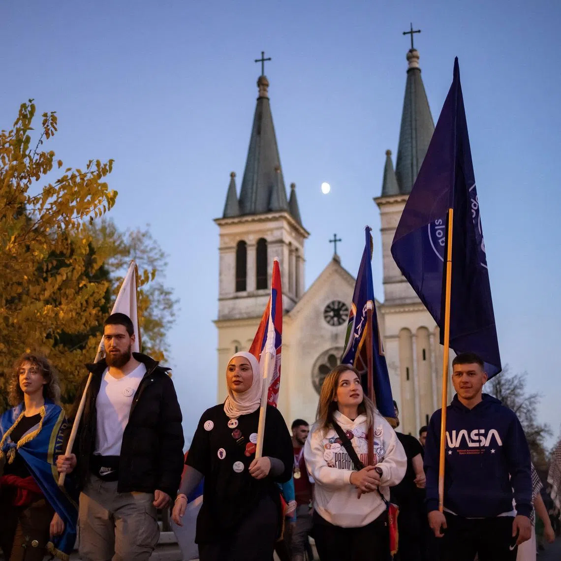 Students from Novi Pazar walk past a church before entering Novi Sad, after completing a walk of more than 400 km from Novi Pazar, in Novi Sad, Serbia, October 31, 2025. A year-long blockade of Novi Pazar University by the students, which had stopped lectures from taking place, ended little over a week ago, after the replacement of the university's rector and the reversal of a ban on 200 students, who had been expelled for their anti-government activism. Their protest outlasted those at most other universities in Serbia, and saw students occupy the buildings even after authorities had cut the heating. REUTERS/Marko Djurica