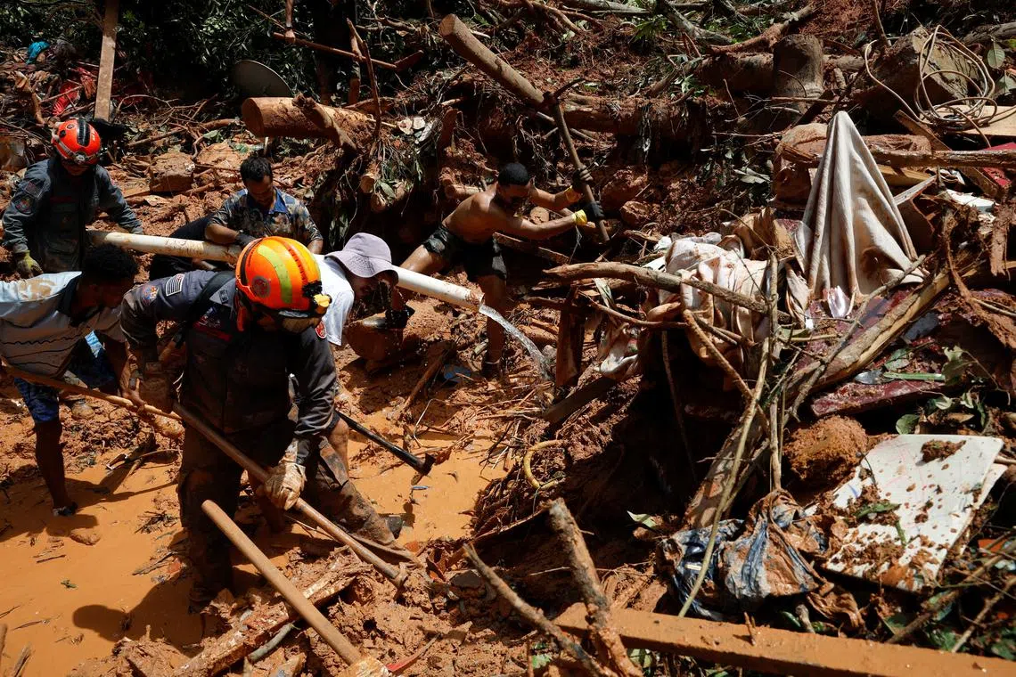 Volunteers and firefighters working to find victims in one of the landslides sites after severe rainfall at Barra do Sahy in Sao Sebastiao, Brazil, on Feb 21, 2023.