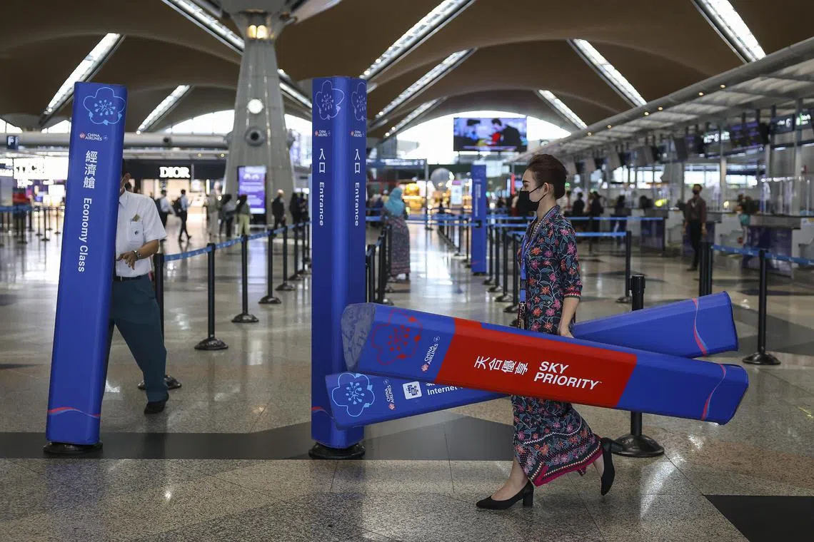 Workers prepare the pillar of China Airlines near the check-in counter, inside Kuala Lumpur International Airport (KLIA) in Sepang, Malaysia, on Jan 4, 2023.