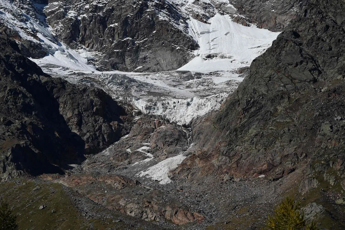 (FILES) In this file photo taken on September 26, 2015 One of the glaciers of the Monte Rosa (top) slides till the Belvedere Glacier (bottom) on September 26, 2015. The Belvedere Glacier is a valley glacier, mostly covered by rocks, located above Macugnaga in the region of Piedmont. The glacier lies at the base of the east face of Monte Rosa and reaches a height of about 1.800 meters above sea level at its lowest point, and lost 3,1 m of thickness of ice in the last 6 month at its lower point. AFP PHOTO / OLIVIER MORIN (Photo by Olivier MORIN / AFP)