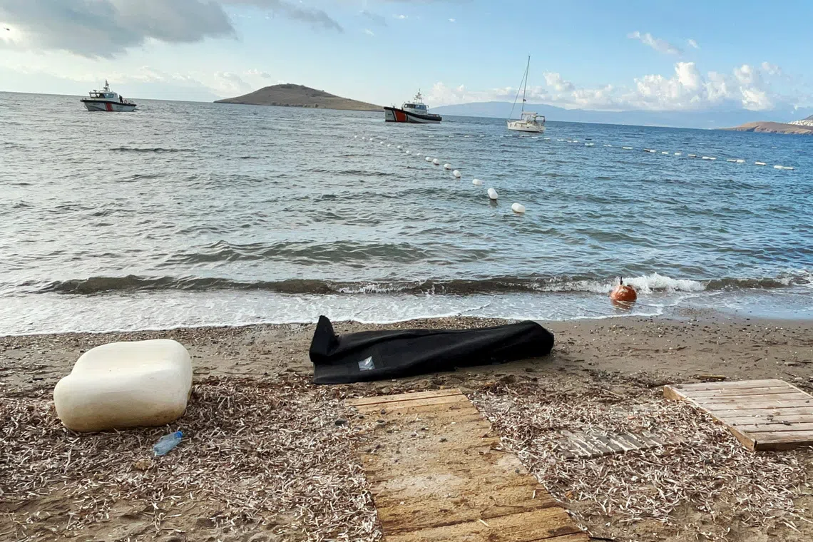 A body bag lies on the shore as Coast Guard Command members conduct a search and rescue operation following the sinking of a migrant boat off Bodrum, western Mugla province, Turkey, October 24, 2025. REUTERS/Kenan Gurbuz