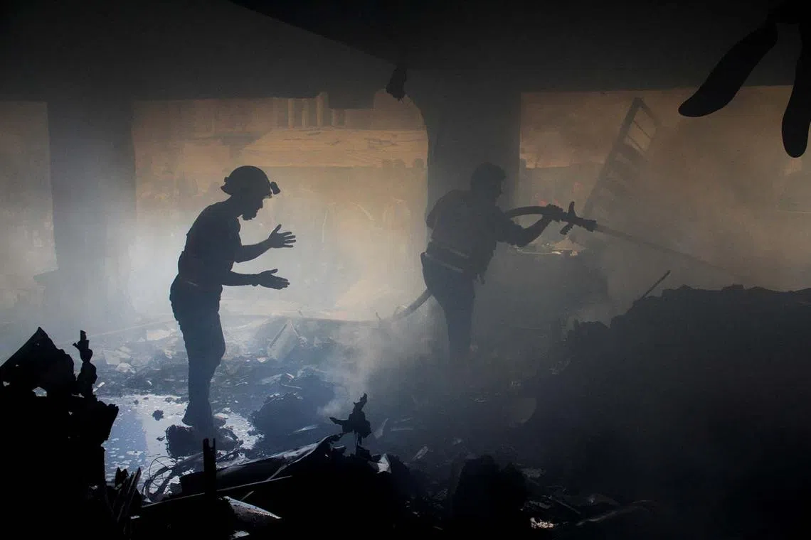 Palestinians working to extinguish fire at a school sheltering displaced people, after it was hit by an Israeli strike, in Gaza City Nov 14, 2024. 