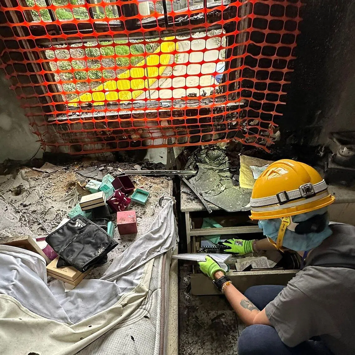Mr Bowie Chan shows his wife, Ms Annie Tse, going through drawers in their flat at the fire-ravaged Wang Fuk Court in Hong Kong.
