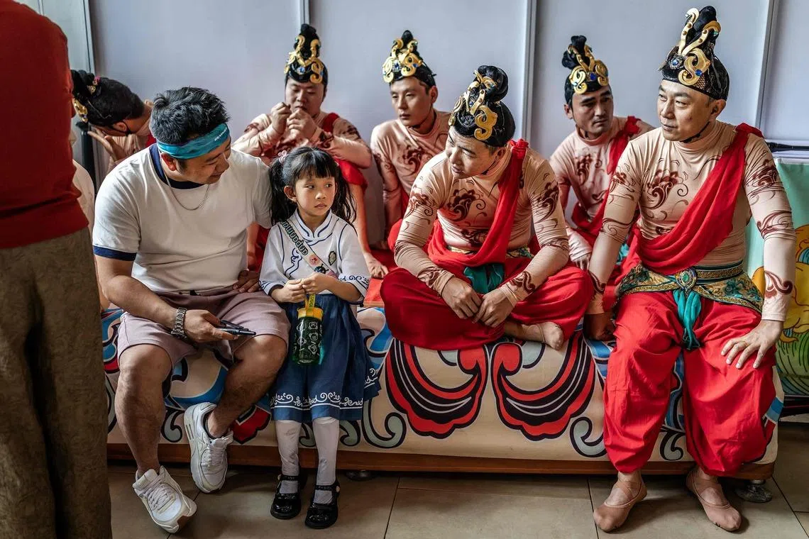 Performers speaking with a young girl as they wait to take the stage during celebrations marking the Chinese Lunar New Year in Nairobi, Kenya on Feb 8, 2026, ahead of the upcoming Lunar New Year of the Horse. 