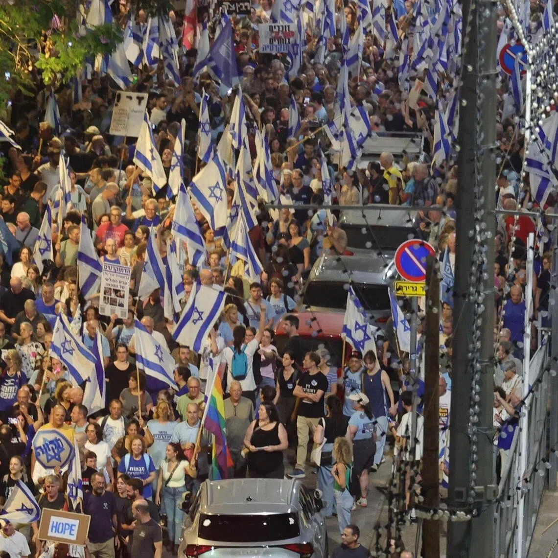 Demonstrators waving national flags and holding banners take part in an anti-government rally in Tel Aviv on Oct 24.