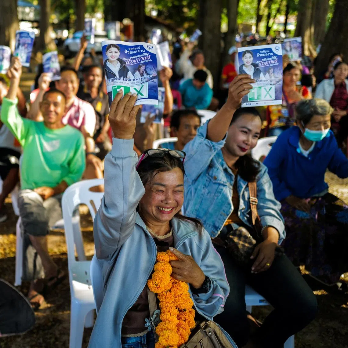 People hold up election campaign brochures of Sudarat Pitakpornpunlop, a parliamentary candidate for the Bhumjaithai Party, during her election campaign rally in Woen Buek village, Khong Chiam district, Ubon Ratchathani province, Thailand, January 24, 2026. REUTERS/Athit Perawongmetha