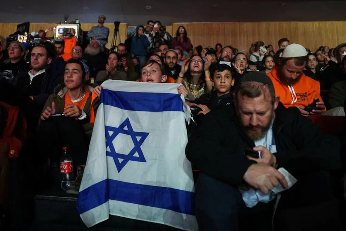 A boy holds an Israeli flag as members of the Israeli settler community gather at a convention calling for Israel to rebuild settlements in the Gaza Strip and the northern part of the Israeli-occupied West Bank, in Jerusalem, January 28, 2024. REUTERS/Ronen Zvulun