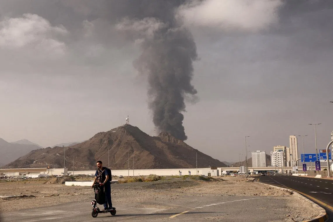 FILE PHOTO: A person rides on a scooter as smoke rises in the Fujairah oil industry zone following a fire caused by debris after interception of a drone by air defenses, in Fujairah, United Arab Emirates, March 3, 2026. REUTERS/Amr Alfiky/File Photo