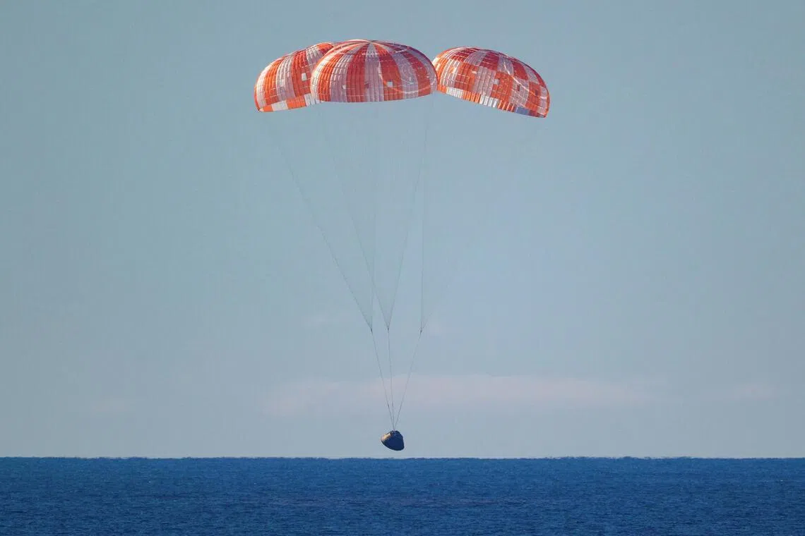 The Artemis II capsule splashes down somewhere in the Pacific Ocean.
