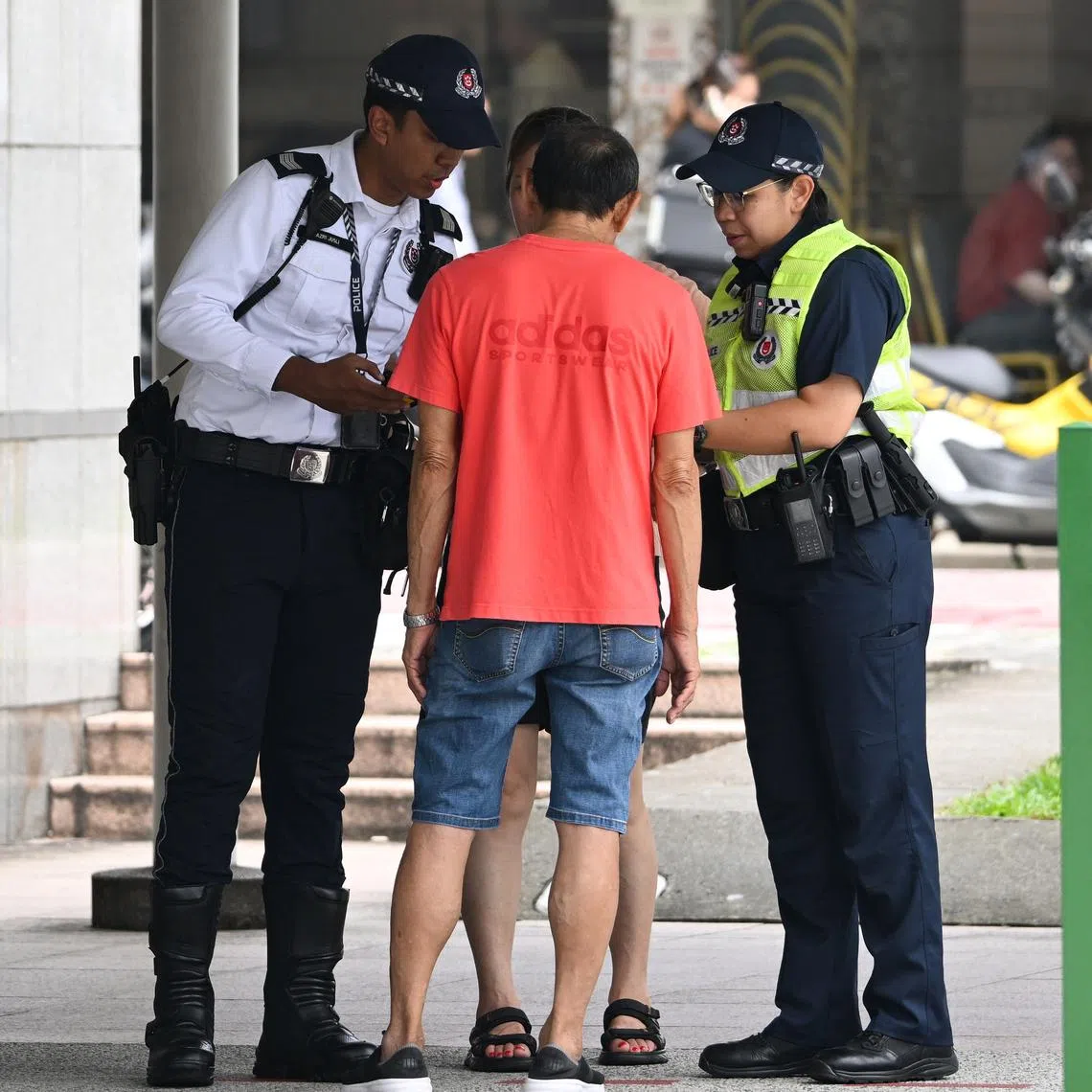 Traffic police officers speaking to jaywalkers who cross the road without using traffic light at Serangoon Road near Boon Keng MRT station on July 13.