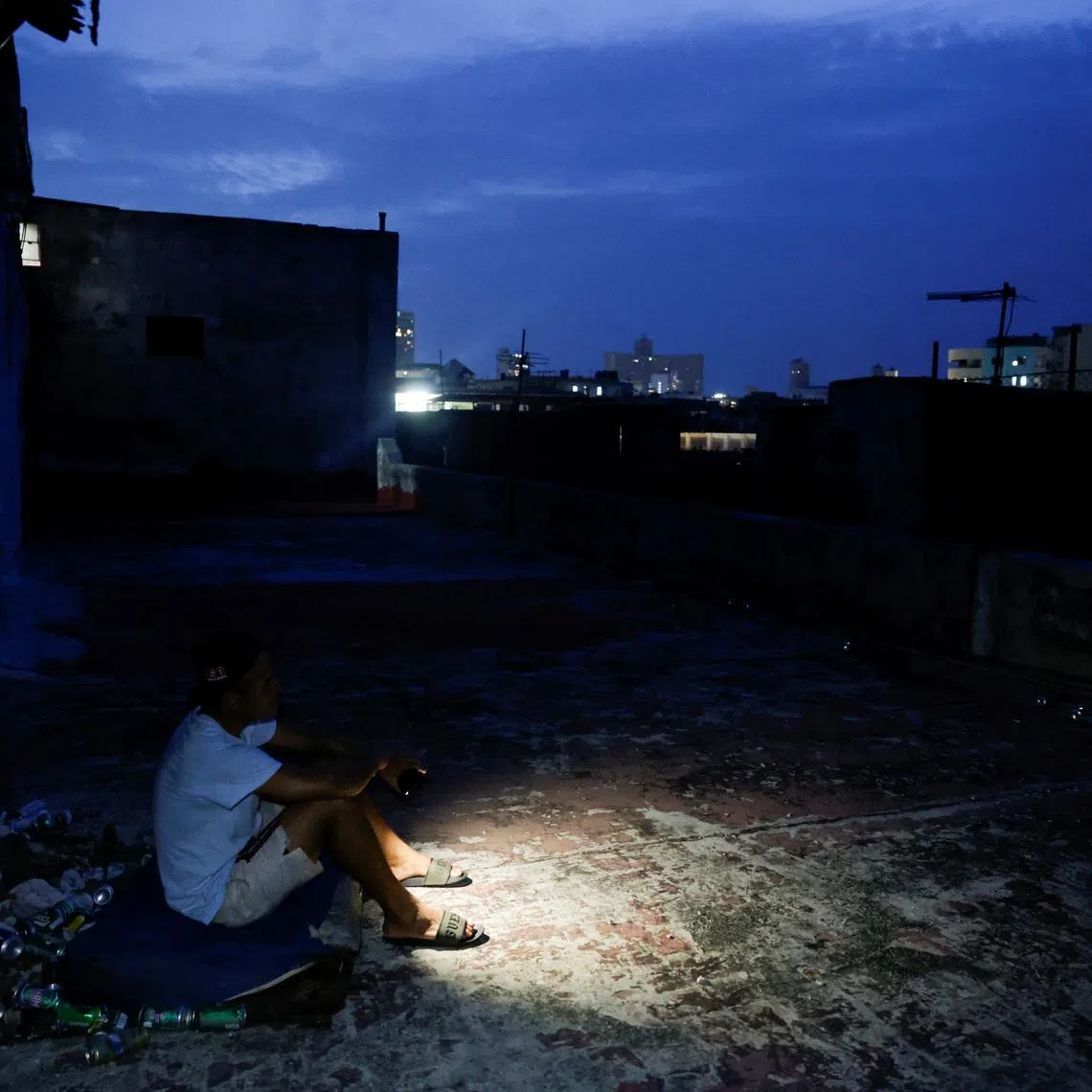 Frank Alfonso, 39, sits on a mattress on the roof of a building to keep cool as Cuba's national power grid collapsed, marking the second total blackout in a week amid a severe energy crisis that has turned power outages into a daily reality, in Havana, Cuba, July 11, 2026. REUTERS/Norlys Perez