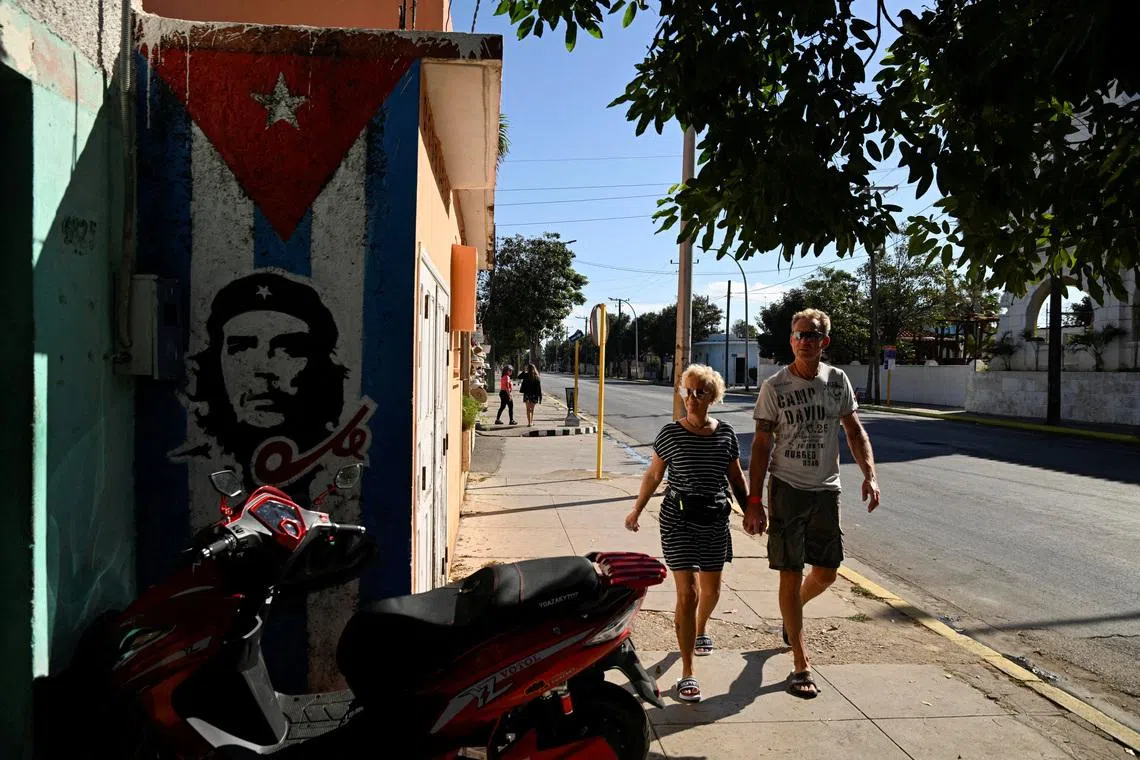 FILE PHOTO: Tourists walk past a mural of late revolutionary hero Che Guevara as the U.S. blocks shipments of oil from reaching the island nation, Varadero, Cuba, February 14, 2026. REUTERS/Norlys Perez/File Photo