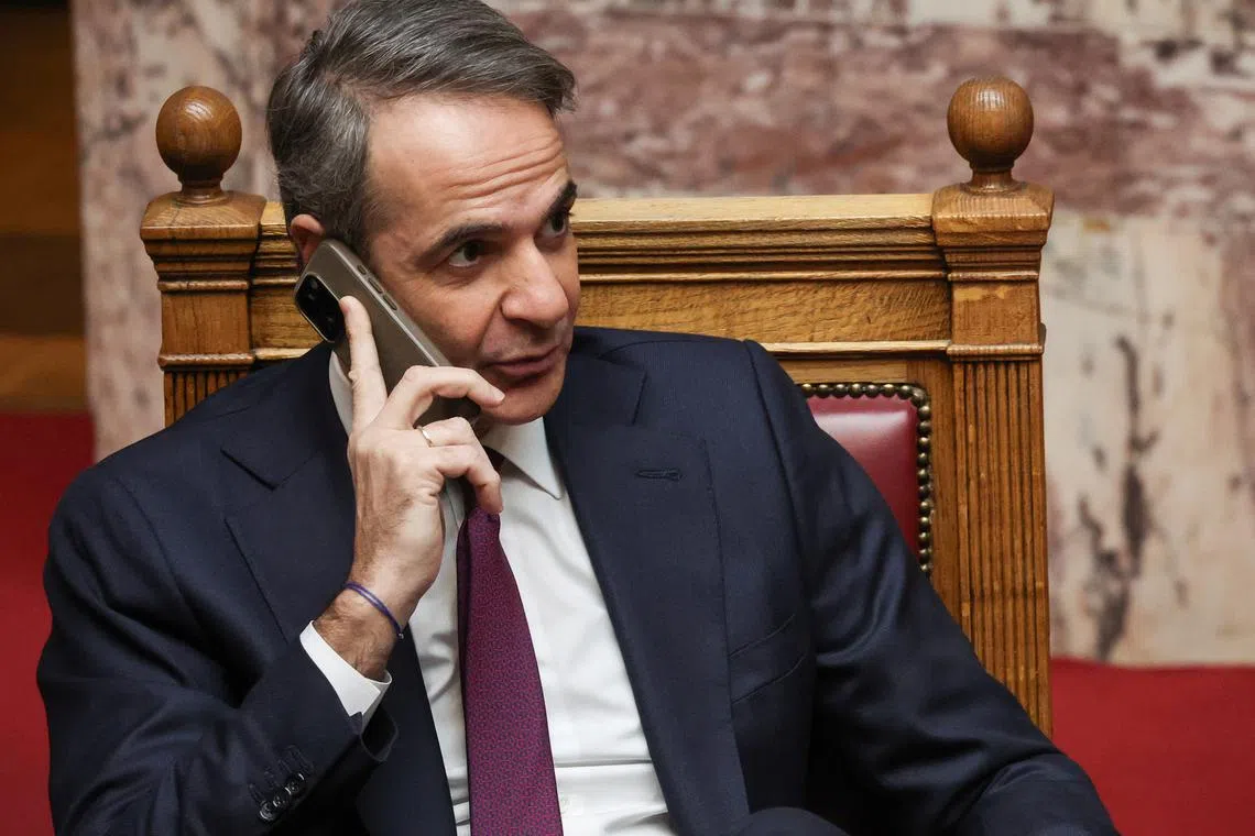Greek prime minister Kyriakos Mitsotakis uses his mobile phone, during the fourth round of the voting for the Greek president, at the Greek parliament in Athens, Greece, February 12, 2025.  REUTERS/Louisa Gouliamaki/File Photo