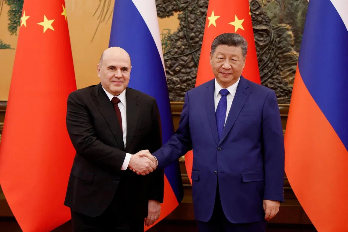Russian Prime Minister Mikhail Mishustin (left) shakes hands with Chinese President Xi Jinping during a meeting at the Great Hall of the People in Beijing, China on Nov 4, 2025.  