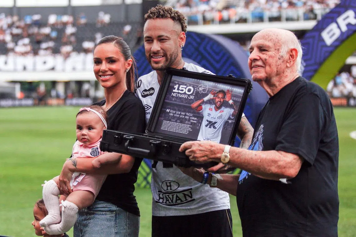 Soccer Football - Brasileiro Championship - Santos v Cruzeiro - Estadio Urbano Caldeira, Santos, Brazil - December 7, 2025 Santos' Neymar with his wife Bruna Biancardi and their daughters after receiving an award from former Santos player Pepe before the match REUTERS/Thiago Bernardes