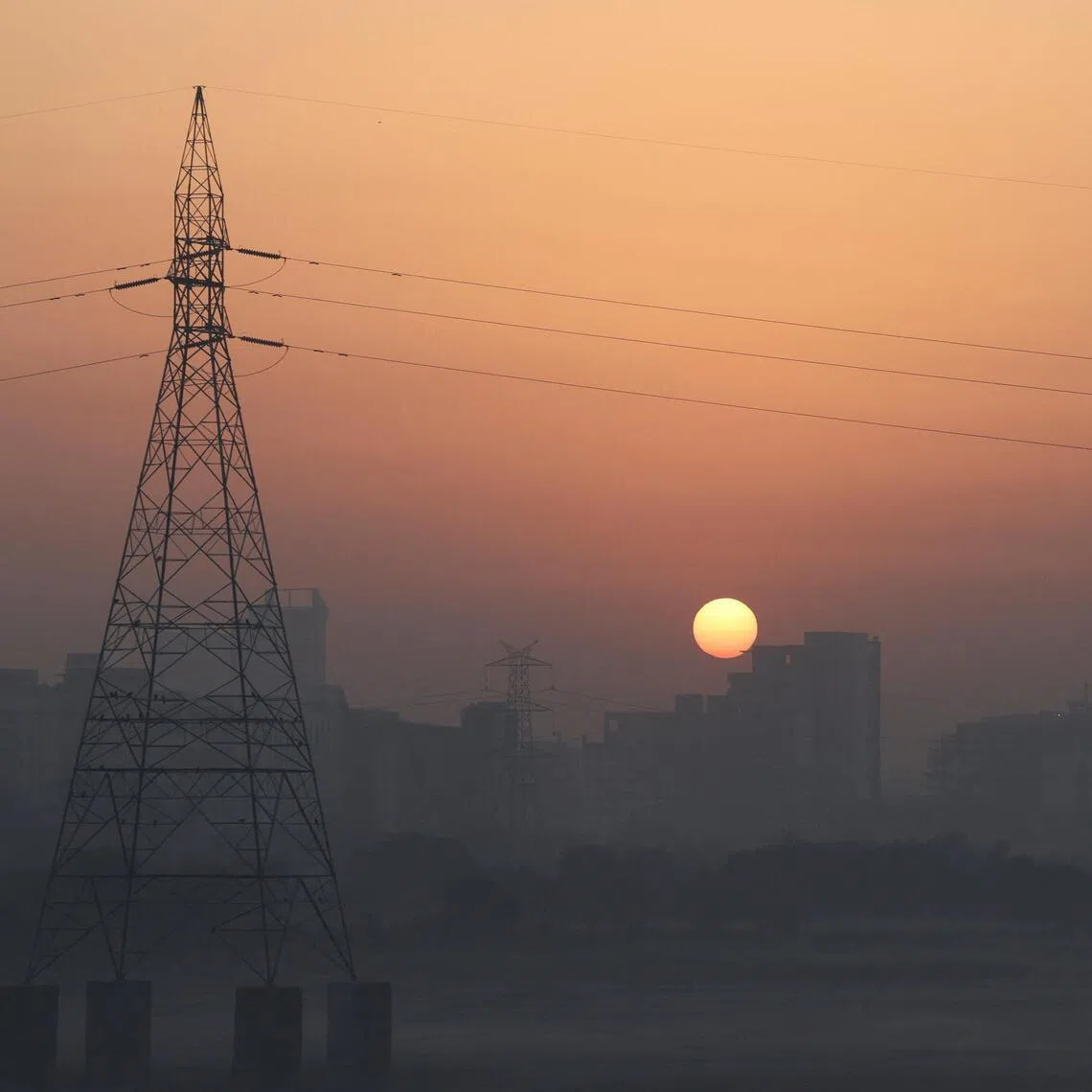 The sun rises behind buildings on a hazy morning in New Delhi, India, on Feb 27.