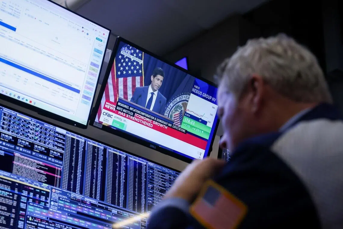 A TV station broadcasting Fed chairman Kevin Warsh on Oct 28, as traders work on the floor of the New York Stock Exchange, in New York City.