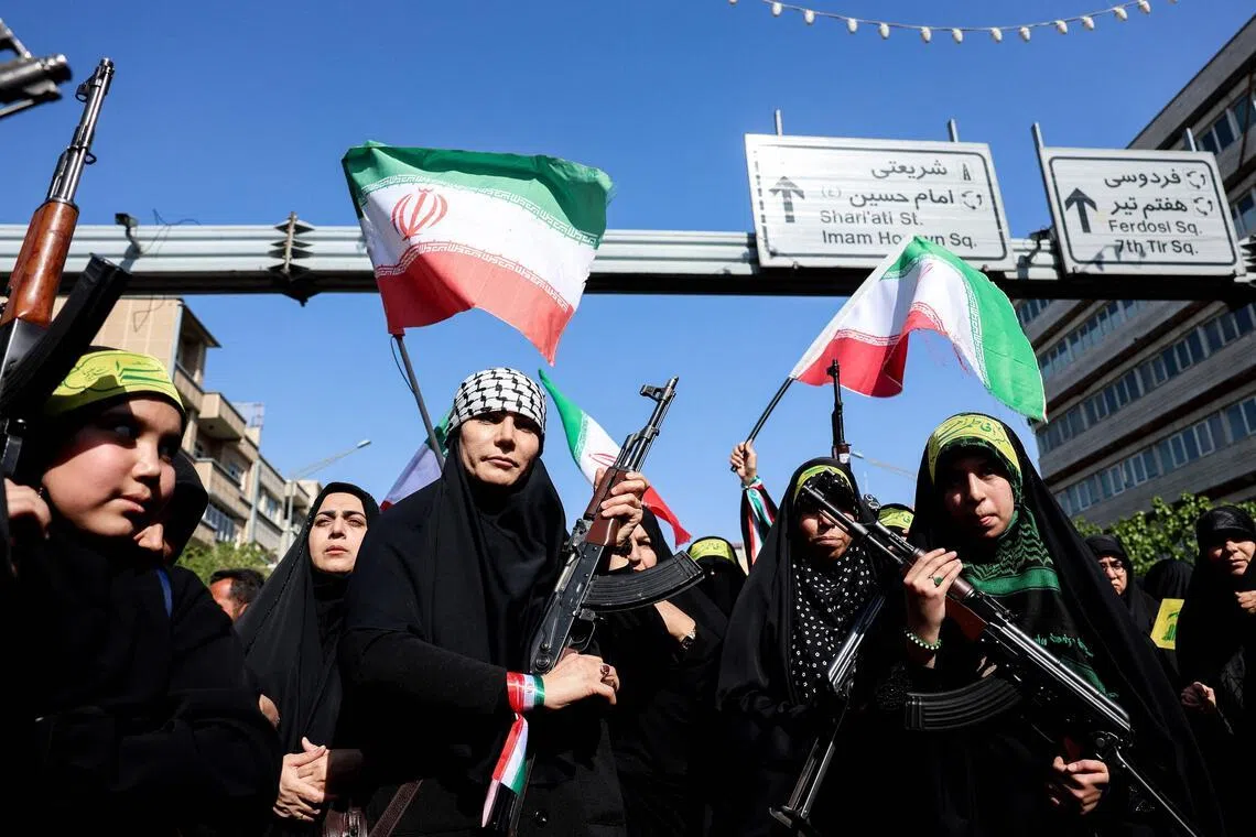 Iranian women brandish their rifles as they take part in a rally paying tribute to women killed during Iran’s war with the US and Israel.
