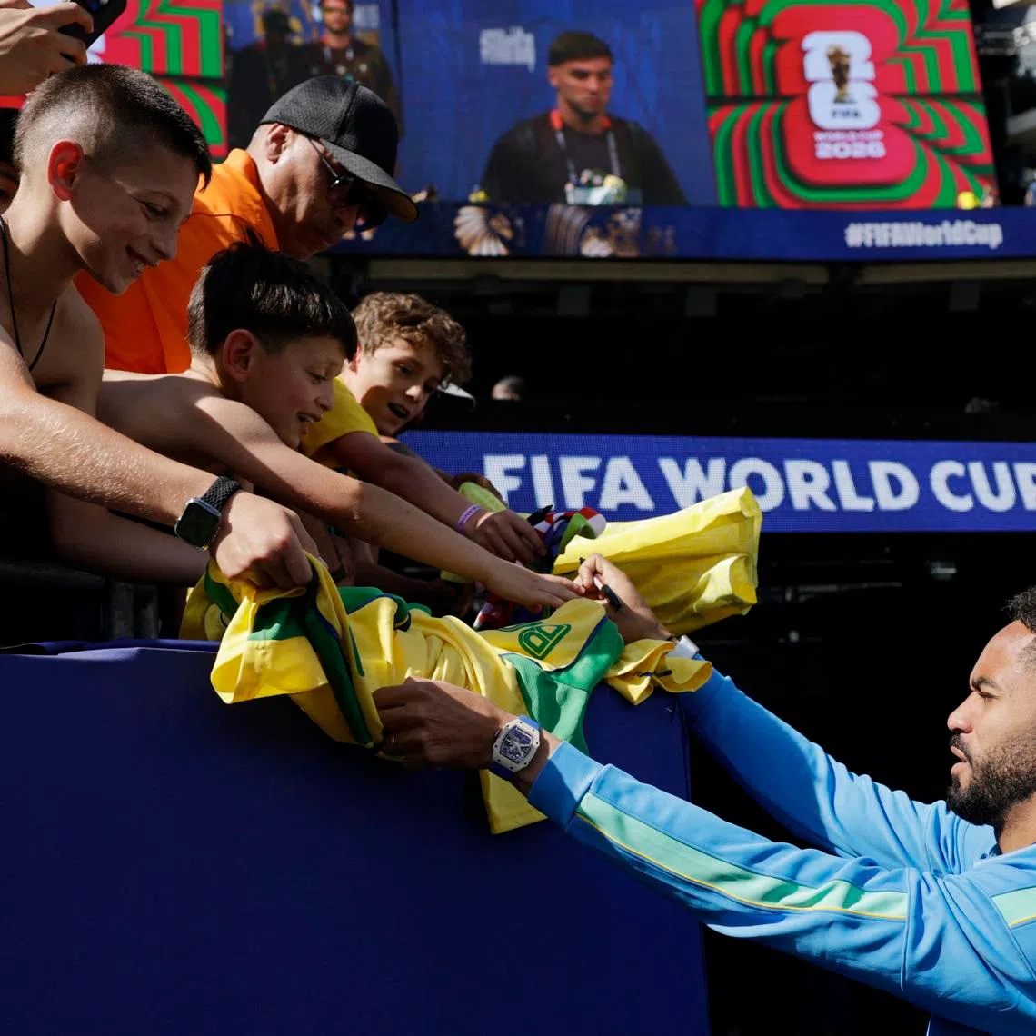 Soccer Football - FIFA World Cup 2026 - Group C - Brazil v Morocco - New York/New Jersey Stadium, East Rutherford, New Jersey, U.S. - June 13, 2026 Brazil's Matheus Cunha signs autographs for fans inside the stadium before the match REUTERS/Jeenah Moon