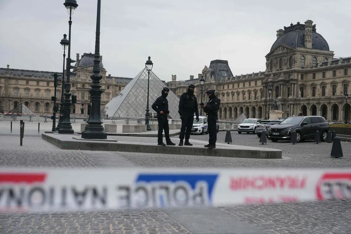 French police officers patrol in front of the Louvre Museum after it was robbed on Oct 19.