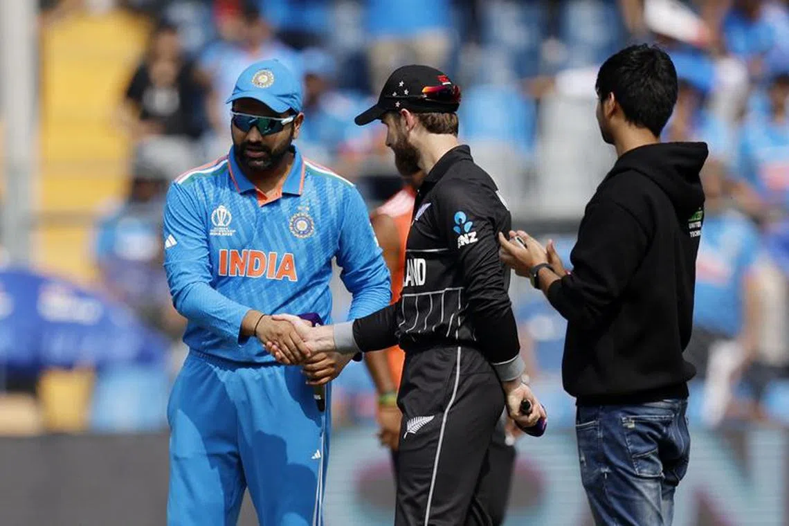 Cricket - ICC Cricket World Cup 2023 - Semi-Final - India v New Zealand - Wankhede Stadium, Mumbai, India - November 15, 2023 India's Rohit Sharma shakes hands with New Zealand's Kane Williamson after winning the coin toss before the match REUTERS/Adnan Abidi