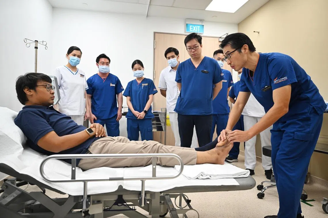 Plastic surgeon Feng Jiajun and the multidisciplianry team from Sengkang General Hospital manage the health of diabetes patient Muhammad Sufian Rahim's salvaged foot. The 33-year-old customer service facilities manager  had a toe removed and a flap created to save his foot. 

ST Photo: Azmi Athni