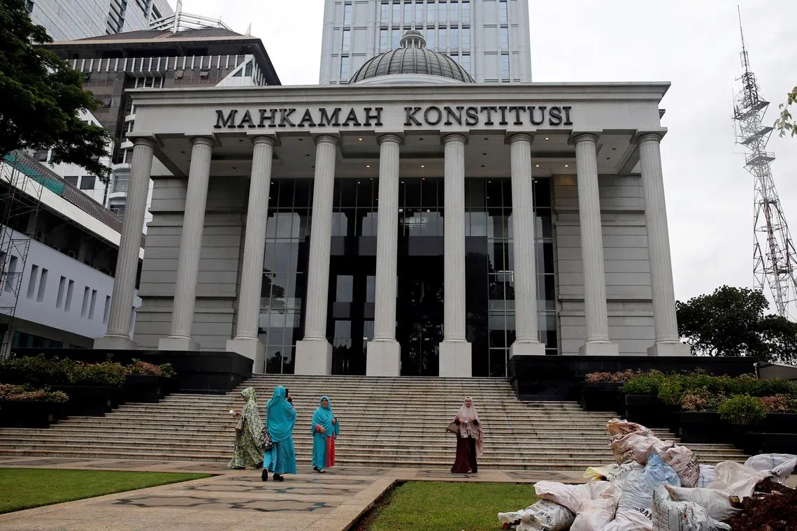 FILE PHOTO: Muslim women walk in front of Indonesia's constitutional court after attending a trial in Jakarta, Indonesia, December 14, 2017. REUTERS/Beawiharta/File Photo