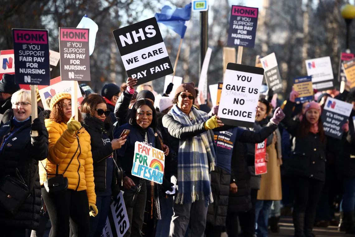 NHS nurses hold placards during a strike, amid a dispute with the government over pay, outside St Thomas' Hospital in London, on Dec 15, 2022.