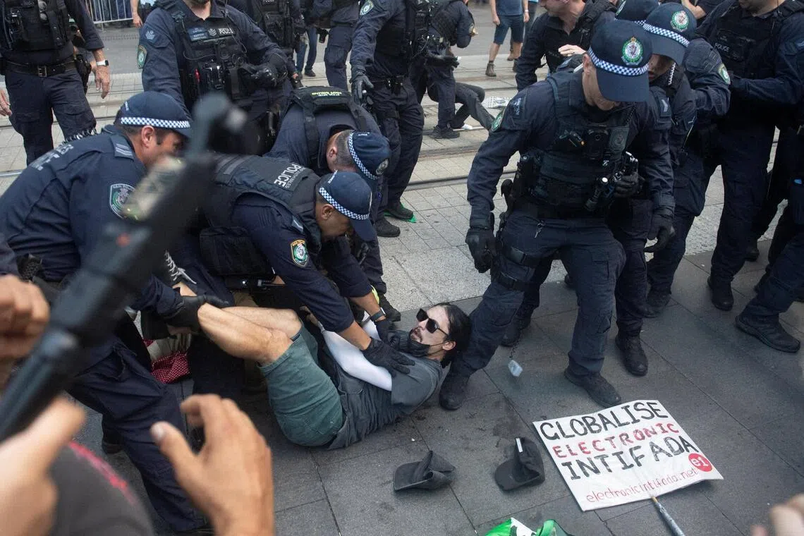 Police officers pin down a protester during a protest against Israeli President Isaac Herzog's state visit to Australia.
