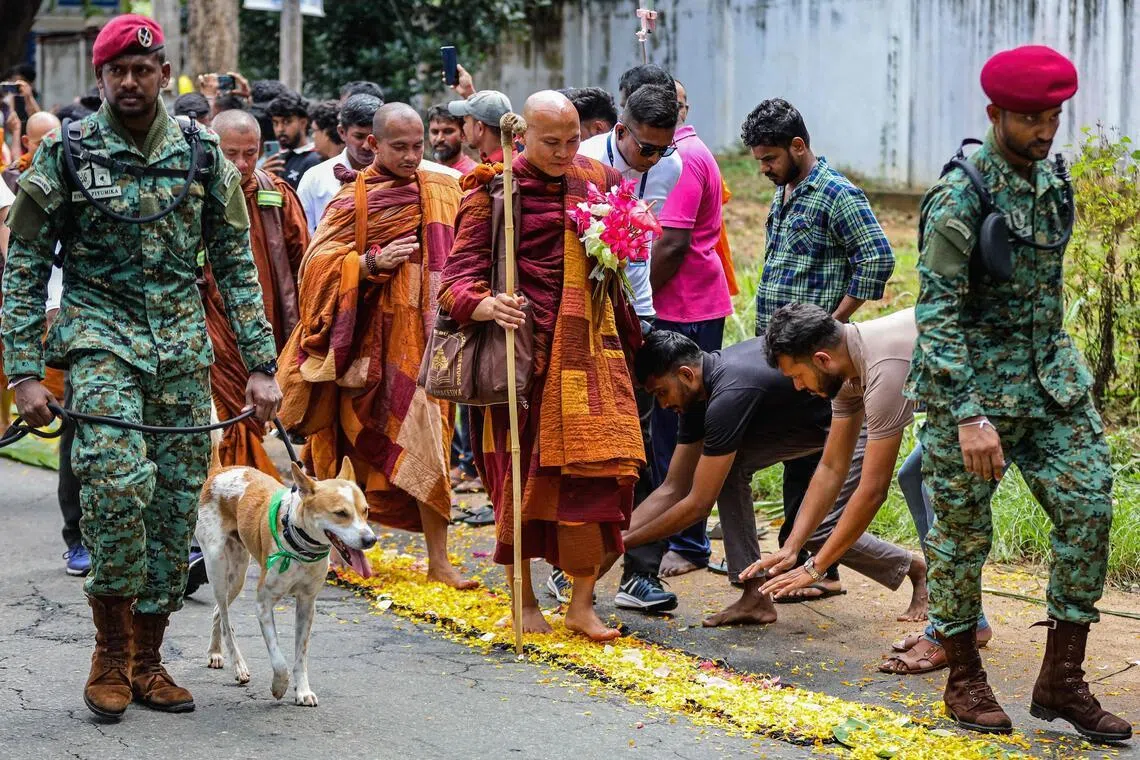 Vietnamese Buddhist monk Bhikkhu Pannakara (centre) accompanied by Sri Lankan army commandos walks with his pet dog Aloka, a stray rescued from India, at the start of the 'Walk For Peace' pilgrimage, on April 22.