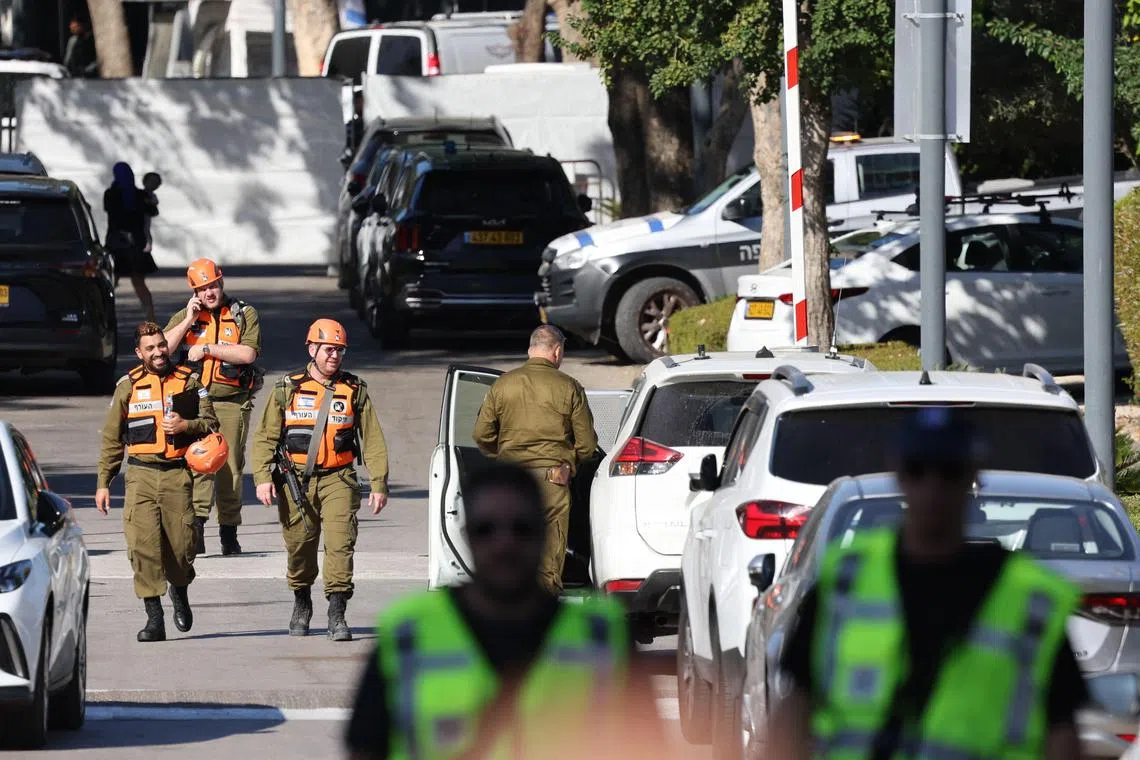 Security forces walk along a street leading to Prime Minister Benjamin Netanyahu's home that Hezbollah targeted with a drone strike. 