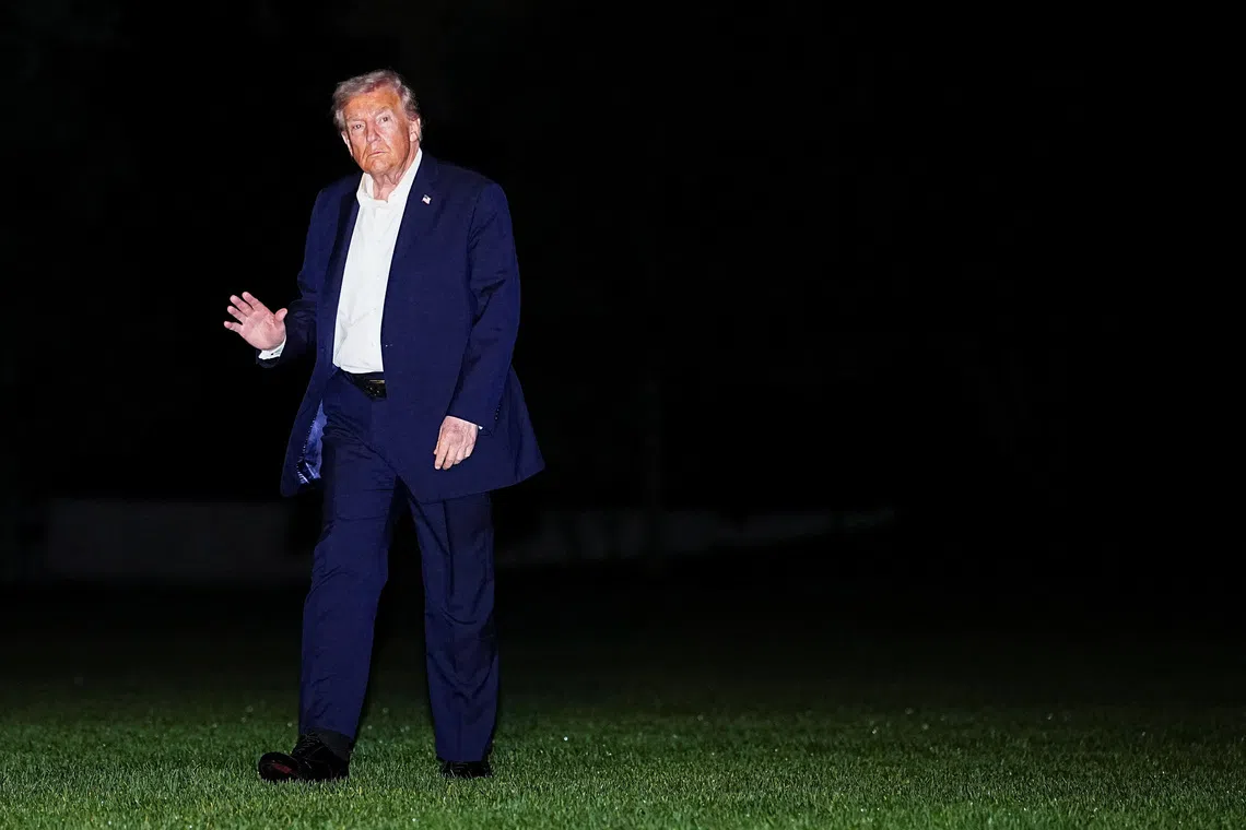 U.S. President Donald Trump waves while walking on the South Lawn as he arrives back at the White House, after participating in a world leaders' summit in Egypt on ending the Gaza war, amid a ceasefire between Israel and Hamas in Gaza, in Washington, D.C., U.S., October 14, 2025. REUTERS/Aaron Schwartz