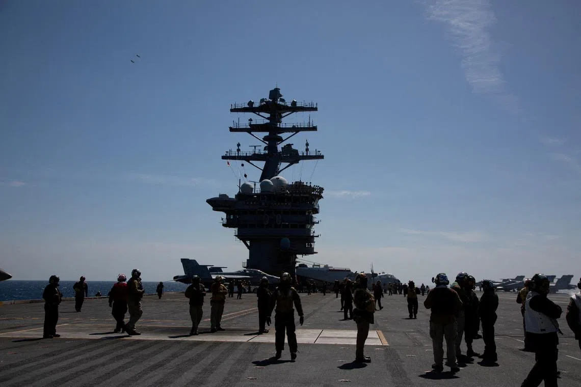 FILE PHOTO: Crews are seen on the flight deck of the USS Nimitz, off the coast of Busan, South Korea, 27 March 2023/Pool via REUTERS/File Photo