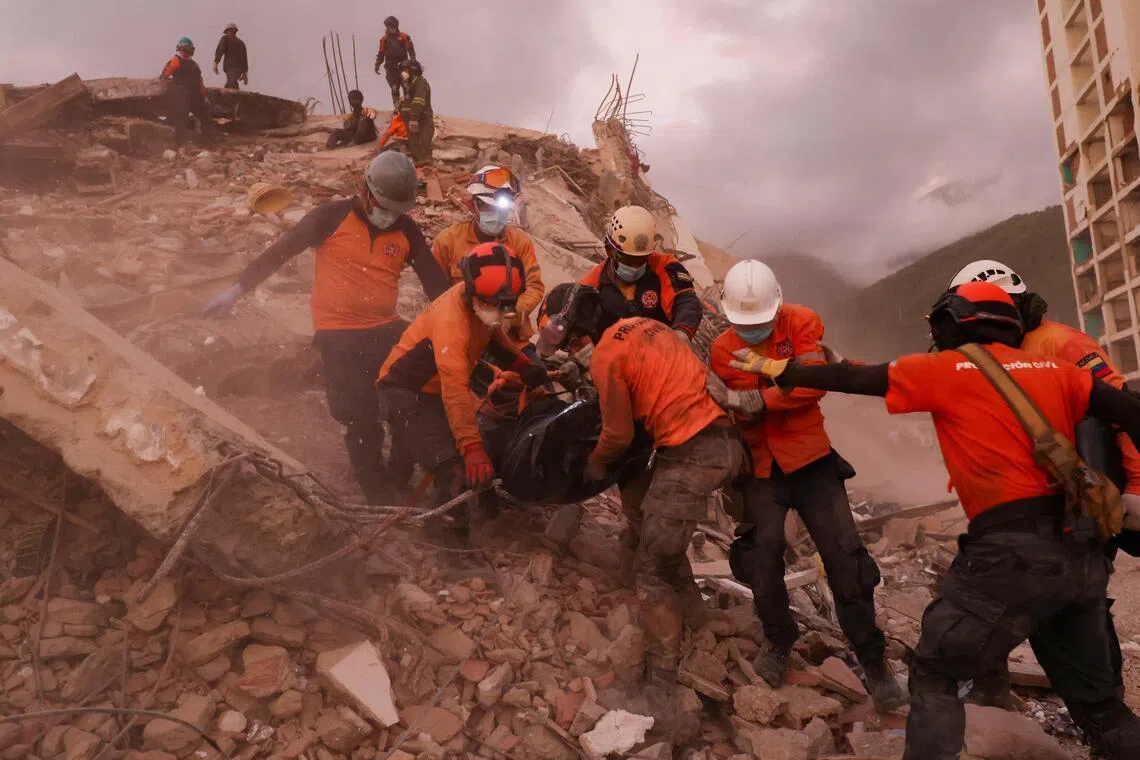 Rescuers carry a body bag of a victim amidst the rubble of a building, in the aftermath of the June 24 earthquakes, in La Guaira, Venezuela on July 8.