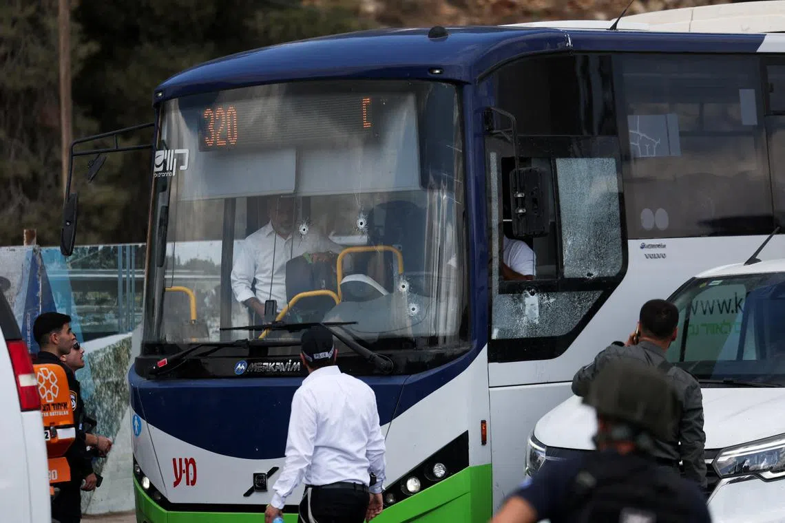 People inspect a bus with bullet holes in the windshield at the scene where a suspected shooting attack took place at the outskirts of Jerusalem, September 8, 2025 REUTERS/Ronen Zvulun     TPX IMAGES OF THE DAY