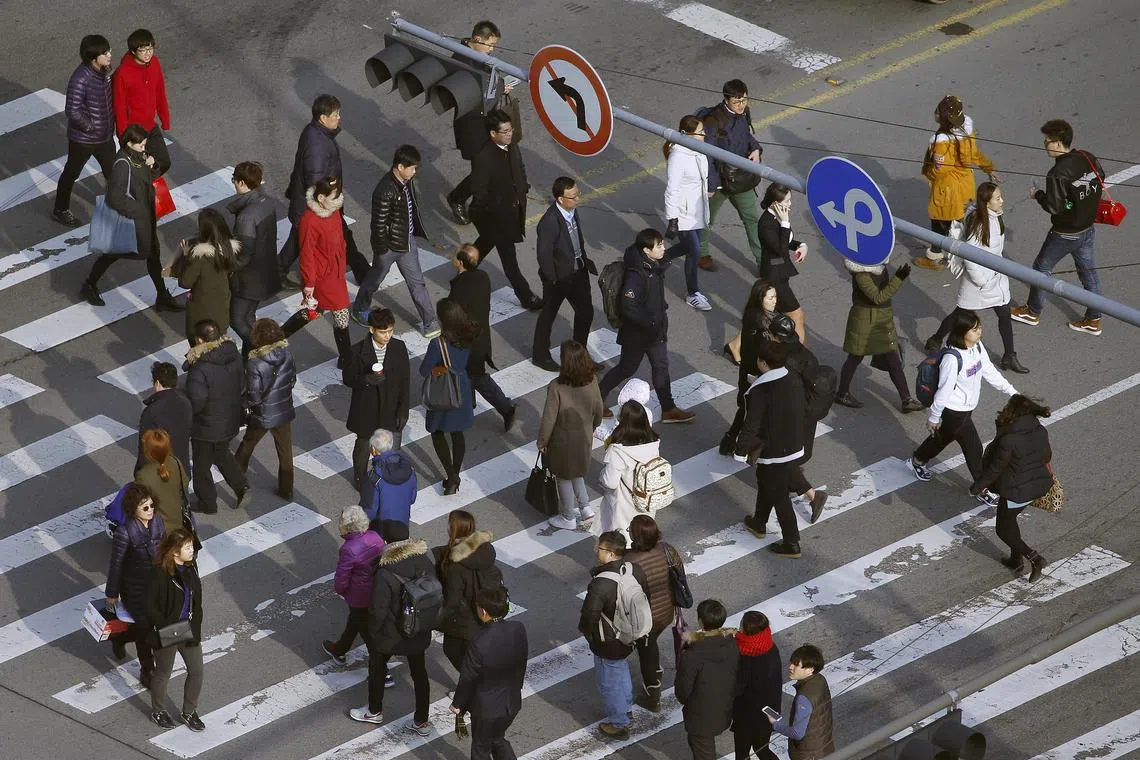 FILE PHOTO: People cross a zebra crossing in a business district in central Seoul, South Korea, December 15, 2015. Picture taken on December 15, 2015.   REUTERS/Kim Hong-Ji/File Photo