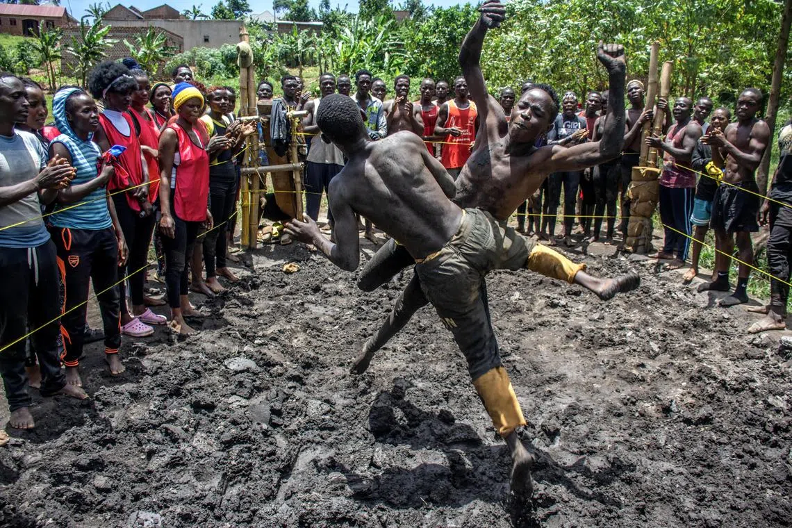 Uganda wrestlers compete in a makeshift wrestling ring at their camp in the village of Kilangila, Mukono district. The members, mainly orphans and underprivileged youth, compete in the ring composed of soft soil, bamboo ring posts and string ropes, unlike the professional rings known in Western countries. 