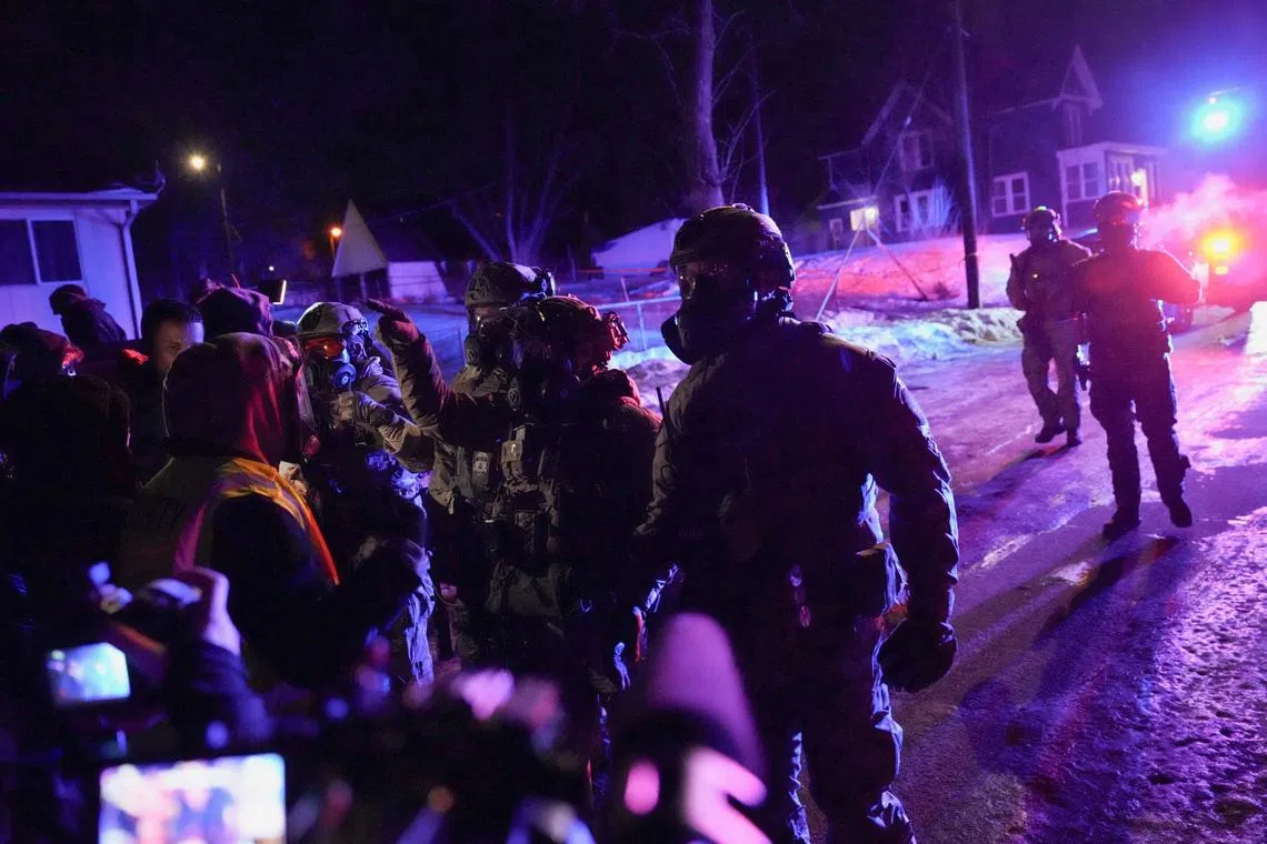 Members of law enforcement interact with protesters, as tensions rise after federal law enforcement agents were involved in a shooting incident, a week after a U.S. Immigration and Customs Enforcement (ICE) agent fatally shot Renee Nicole Good, in north Minneapolis, Minnesota, U.S., January 14, 2026. REUTERS/Leah Millis