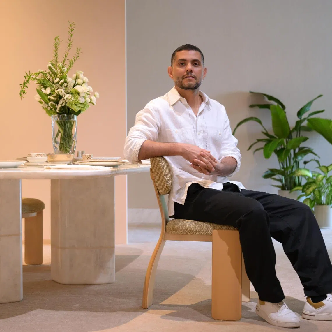 Louis Vuitton's Home Collections designer Cristian Mohaded at the Louis Vuitton Savoir Rever event at Mett Singapore hotel in Fort Canning.. He is pictured with two of his designs - the Pegaso Chair and the Atlas Table.