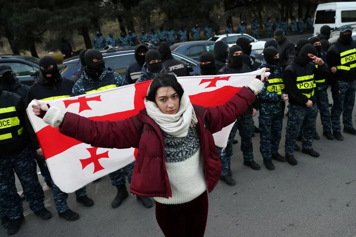 FILE PHOTO: A protester holds a Georgian flag during an anti-government rally demanding new parliamentary elections in Tbilisi, Georgia February 2, 2025. REUTERS/Irakli Gedenidze/File Photo