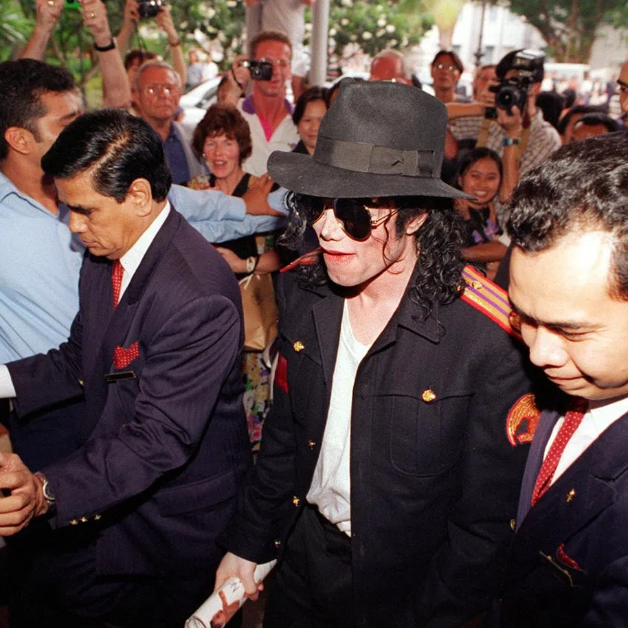 Michael Jackson surrounded by fans and photographers on his arrival at Raffles Hotel in October 1996 for his world tour to promote his HIStory album.