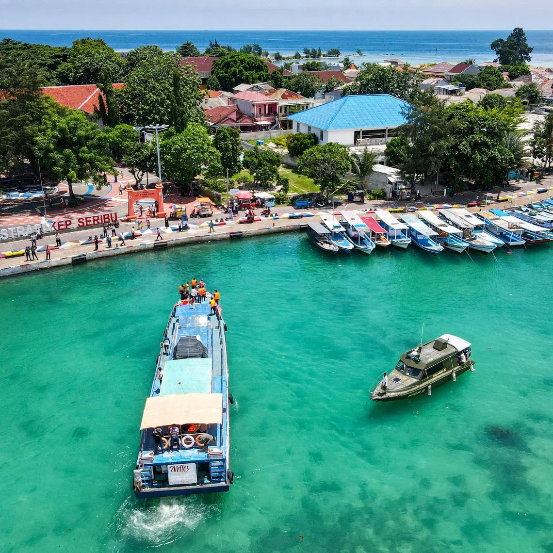 This aerial photo shows a motorboat carrying ballot boxes arriving at Pramuka Island of the Thousand Islands in Jakarta on February 9, 2024, ahead of Indonesia's presidential and legislative polls scheduled to be held on February 14. (Photo by BAY ISMOYO / AFP)