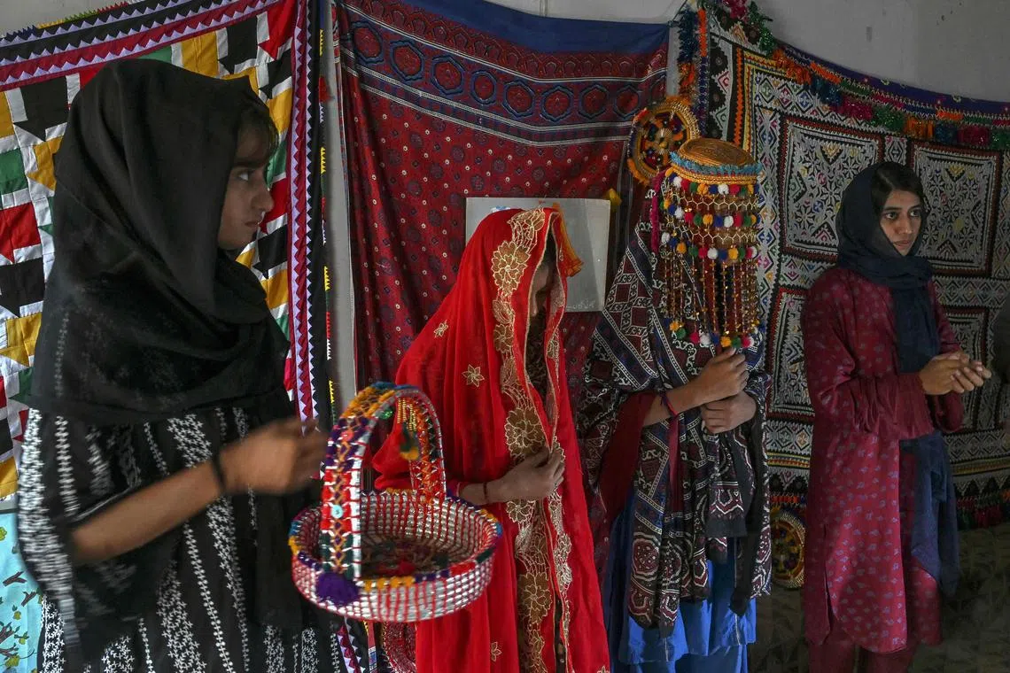 In this photograph taken on August 4, 2024 social workers at NGO Sujag Sansar take part in a theatre practice ahead of their performance, intending to create awareness on dangers of child-marriages at the NGO office in Johi, Dadu district of Sindh province. As monsoon rains were about to break over Pakistan, 14-year-old Shamila and her 13-year-old sister Amina were married off in exchange for money, a decision their parents made to help the family survive the threat of floods. Pakistan's high rate of marriages for underage girls had been inching lower in recent years, but after unprecedented floods in 2022 rights workers warn such weddings are now on the rise due to climate-driven economic insecurity. (Photo by Asif HASSAN / AFP) / TO GO WITH 'Pakistan-Climate-Girls' FEATURE