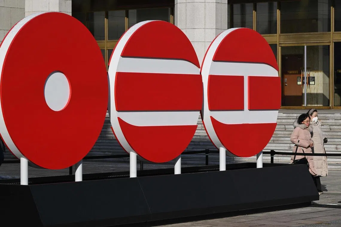 Pedestrians walk past the logo of BTS' 2026 album at Gwanghwamun Square in Seoul on Jan 14, 2026.